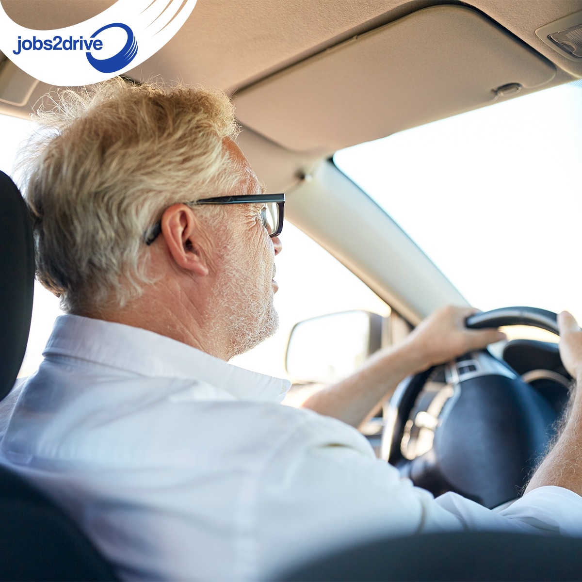 Oudere chauffeur met bril achter het stuur